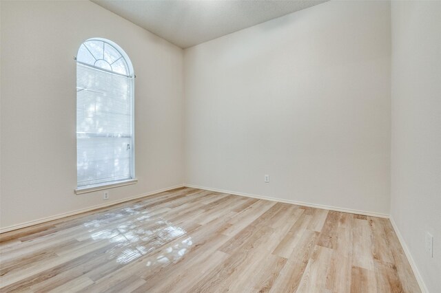 unfurnished room featuring light wood-type flooring and baseboards