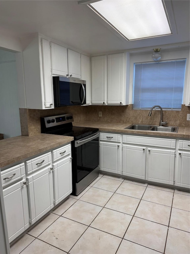 kitchen with stainless steel appliances, sink, and white cabinets