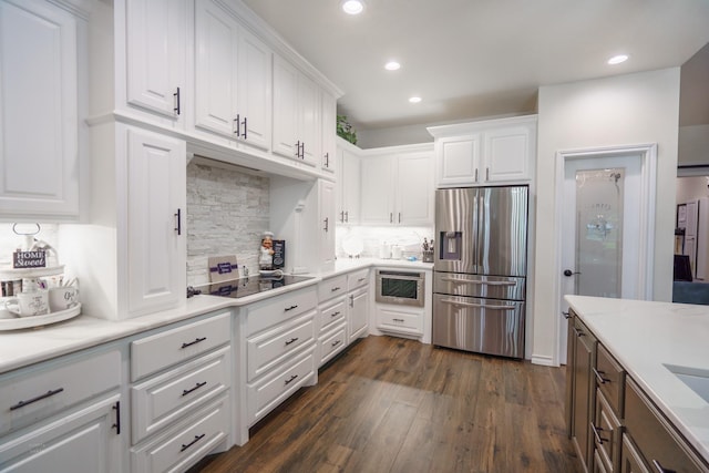 kitchen with black electric stovetop, stainless steel fridge with ice dispenser, decorative backsplash, and white cabinets