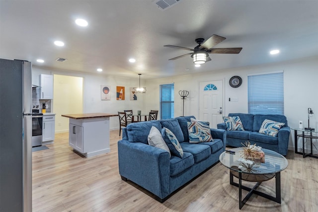 living room with light hardwood / wood-style floors and ceiling fan