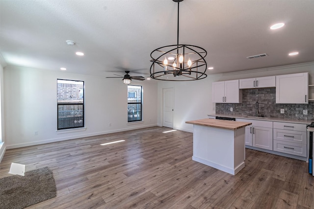 kitchen featuring light wood-type flooring, white cabinets, wood counters, and decorative light fixtures