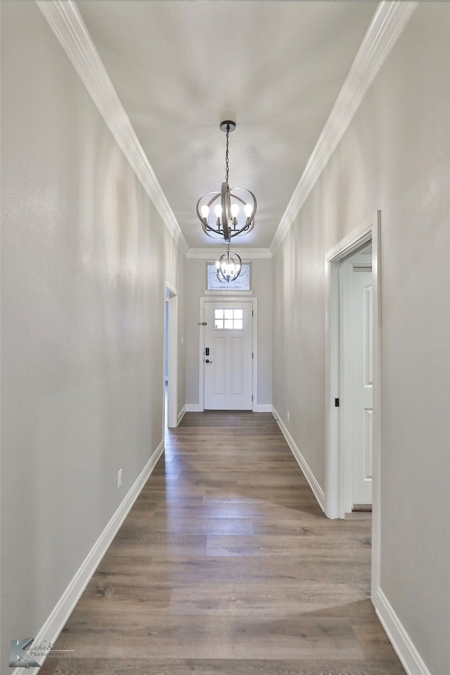 entryway featuring crown molding, hardwood / wood-style flooring, and a notable chandelier