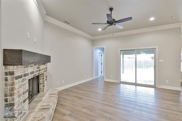 unfurnished living room with crown molding, ceiling fan, a fireplace, and light hardwood / wood-style floors