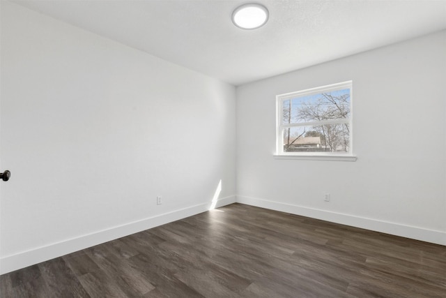 unfurnished room with dark hardwood / wood-style flooring