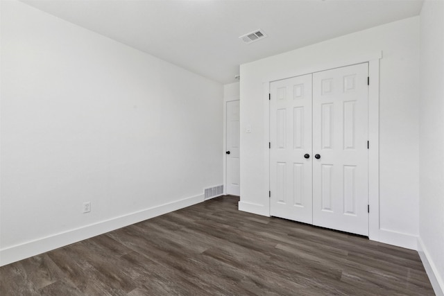 unfurnished bedroom featuring dark hardwood / wood-style floors and a closet