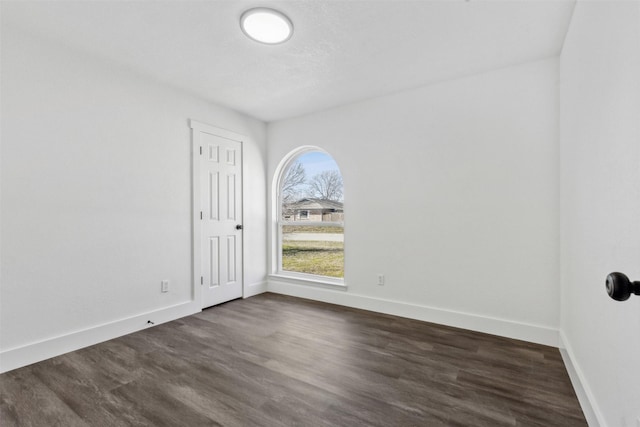 unfurnished room with dark hardwood / wood-style flooring