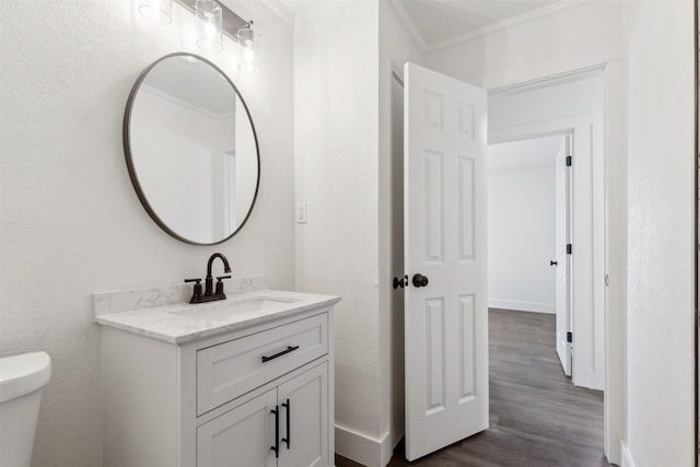 bathroom featuring vanity, crown molding, toilet, and hardwood / wood-style flooring