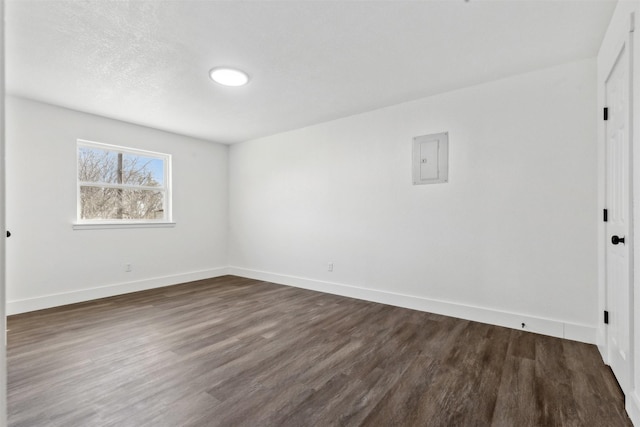 empty room with electric panel and dark hardwood / wood-style floors