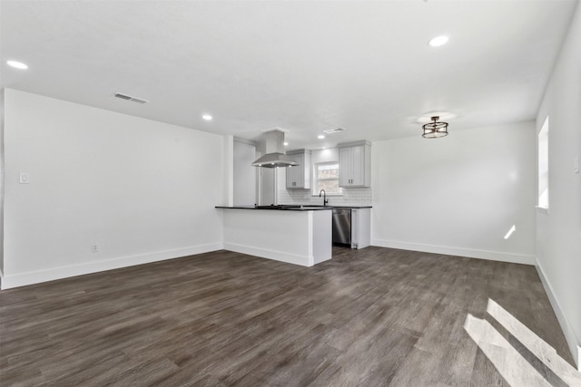 unfurnished living room featuring dark hardwood / wood-style flooring, sink, and a wealth of natural light