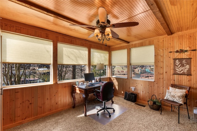 office area with wooden walls, ceiling fan, beam ceiling, and carpet floors