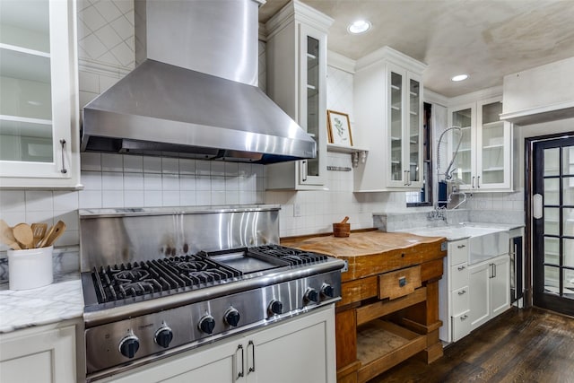 kitchen featuring white cabinetry, stainless steel gas cooktop, wall chimney range hood, and dark hardwood / wood-style flooring