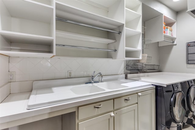 laundry area with cabinets, separate washer and dryer, and sink