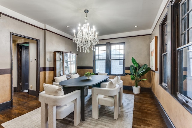 dining space with dark hardwood / wood-style floors and a chandelier