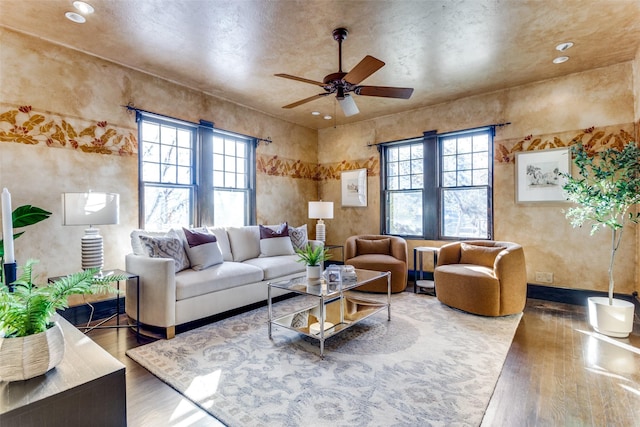 living room with wood-type flooring, a wealth of natural light, and ceiling fan