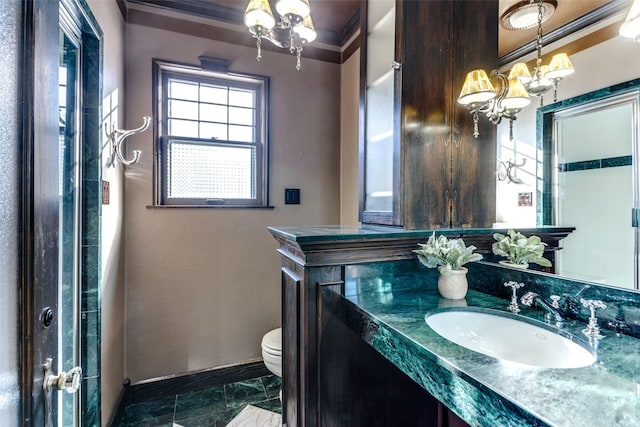 bathroom with crown molding, vanity, an inviting chandelier, and toilet