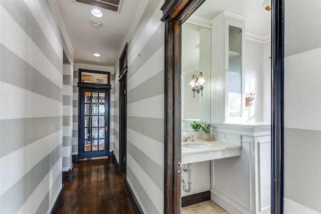 hall with crown molding, sink, and dark wood-type flooring