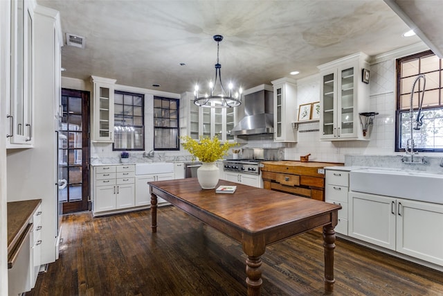 kitchen featuring sink, dishwasher, white cabinets, decorative light fixtures, and wall chimney exhaust hood