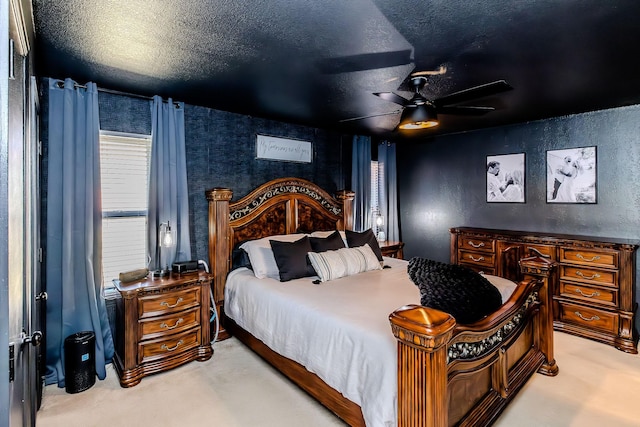 carpeted bedroom featuring ceiling fan and a textured ceiling