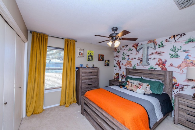 carpeted bedroom with a closet and ceiling fan