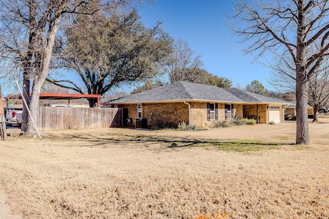 exterior space featuring a yard, a garage, and central AC