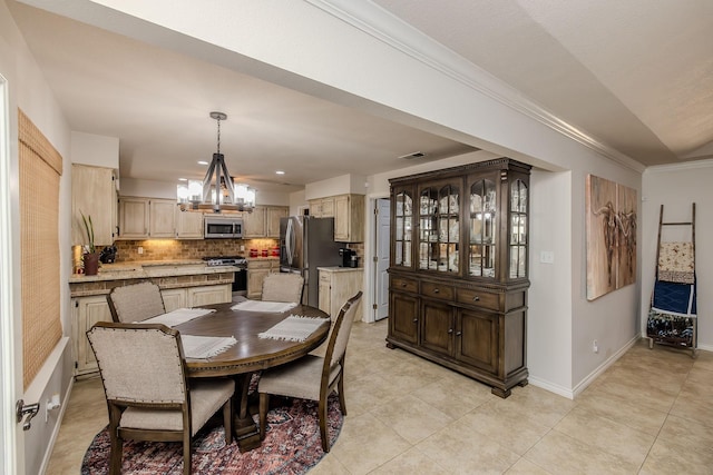 tiled dining area featuring ornamental molding and a chandelier