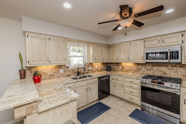 kitchen featuring sink, backsplash, stainless steel appliances, and light stone countertops