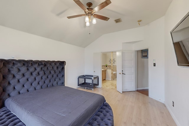 bedroom with ceiling fan, vaulted ceiling, ensuite bath, and light wood-type flooring