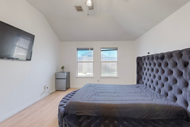 bedroom featuring lofted ceiling, stainless steel refrigerator, ceiling fan, and light wood-type flooring