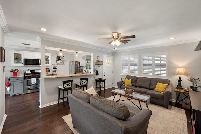 living room with dark wood-type flooring, ceiling fan, and crown molding