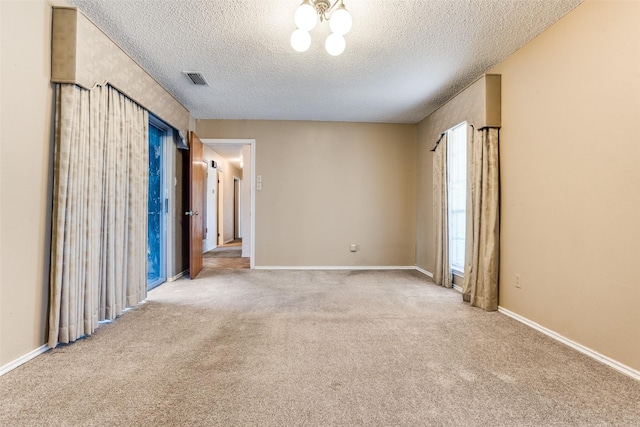 unfurnished bedroom with light carpet, a notable chandelier, and a textured ceiling