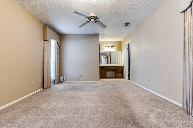 unfurnished living room with ceiling fan, light colored carpet, and a textured ceiling