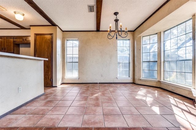 unfurnished dining area with light tile patterned floors, beam ceiling, ornamental molding, a textured ceiling, and a chandelier