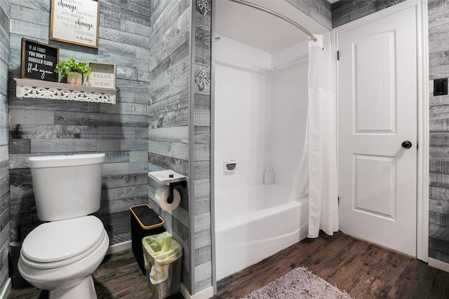 bathroom with shower / bath combination with curtain, wooden walls, wood-type flooring, and toilet