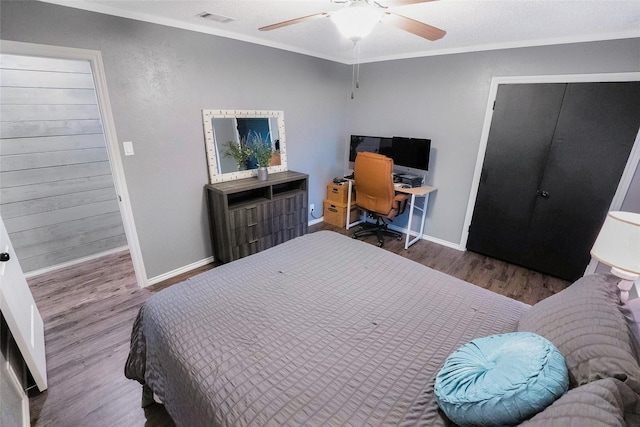 bedroom featuring crown molding, ceiling fan, dark hardwood / wood-style floors, a textured ceiling, and a closet