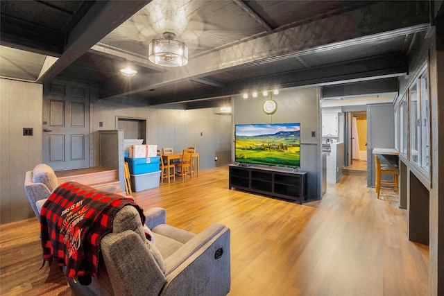 living room with hardwood / wood-style floors, wooden walls, and beamed ceiling