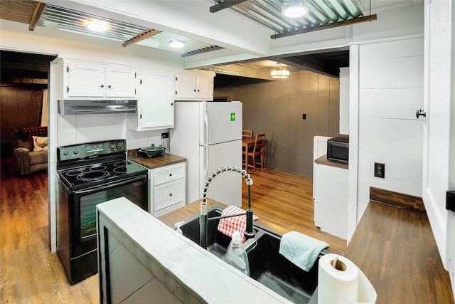 kitchen with hardwood / wood-style flooring, white cabinetry, beamed ceiling, and black appliances