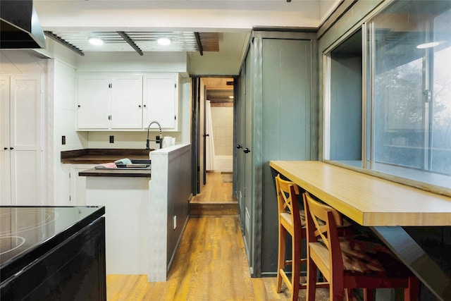 kitchen with white cabinetry and light hardwood / wood-style flooring