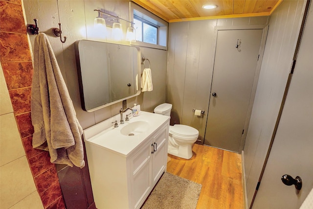 bathroom with wood ceiling, wood-type flooring, toilet, and vanity