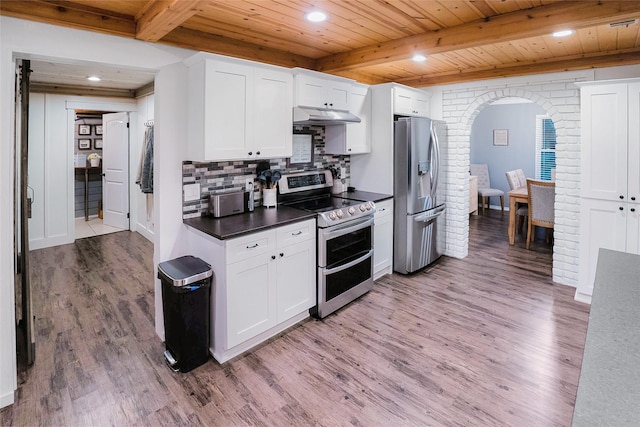 kitchen with stainless steel appliances, brick wall, hardwood / wood-style floors, and white cabinets