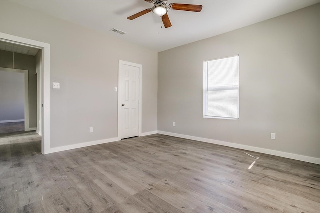 spare room with ceiling fan and light wood-type flooring