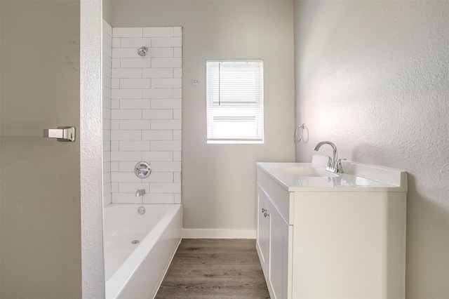 bathroom featuring vanity, wood-type flooring, and tiled shower / bath