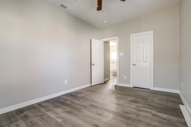 unfurnished bedroom featuring dark hardwood / wood-style flooring, ceiling fan, and a closet