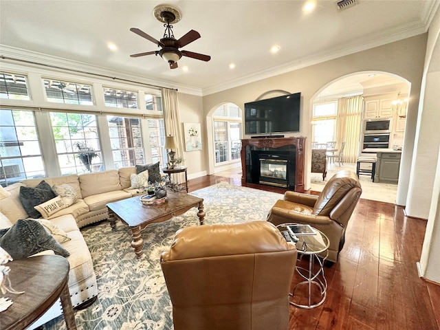 living room with crown molding, ceiling fan, and wood-type flooring