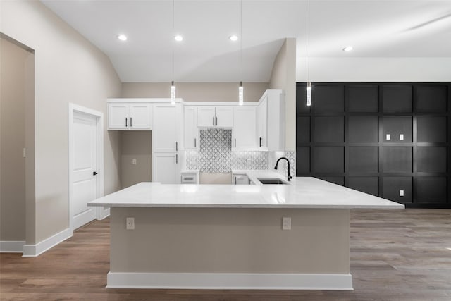 kitchen featuring white cabinetry, sink, pendant lighting, and decorative backsplash