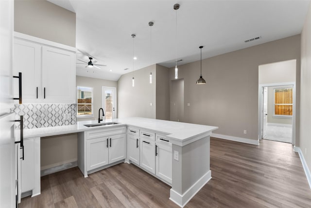 kitchen featuring white cabinetry, hardwood / wood-style flooring, sink, and pendant lighting