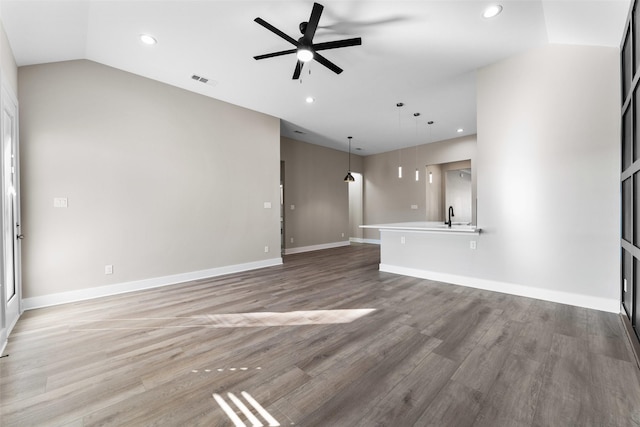 unfurnished living room featuring vaulted ceiling, sink, hardwood / wood-style floors, and ceiling fan