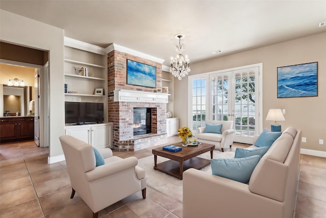 tiled living room featuring a notable chandelier, a fireplace, built in features, and french doors