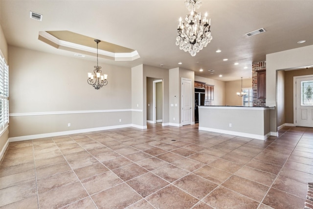 unfurnished living room featuring crown molding, tile patterned floors, a tray ceiling, and a chandelier