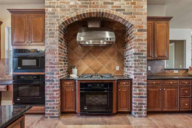 kitchen featuring tasteful backsplash, stainless steel gas cooktop, wall chimney exhaust hood, and double oven