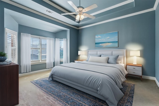 carpeted bedroom featuring crown molding, ceiling fan, and a raised ceiling